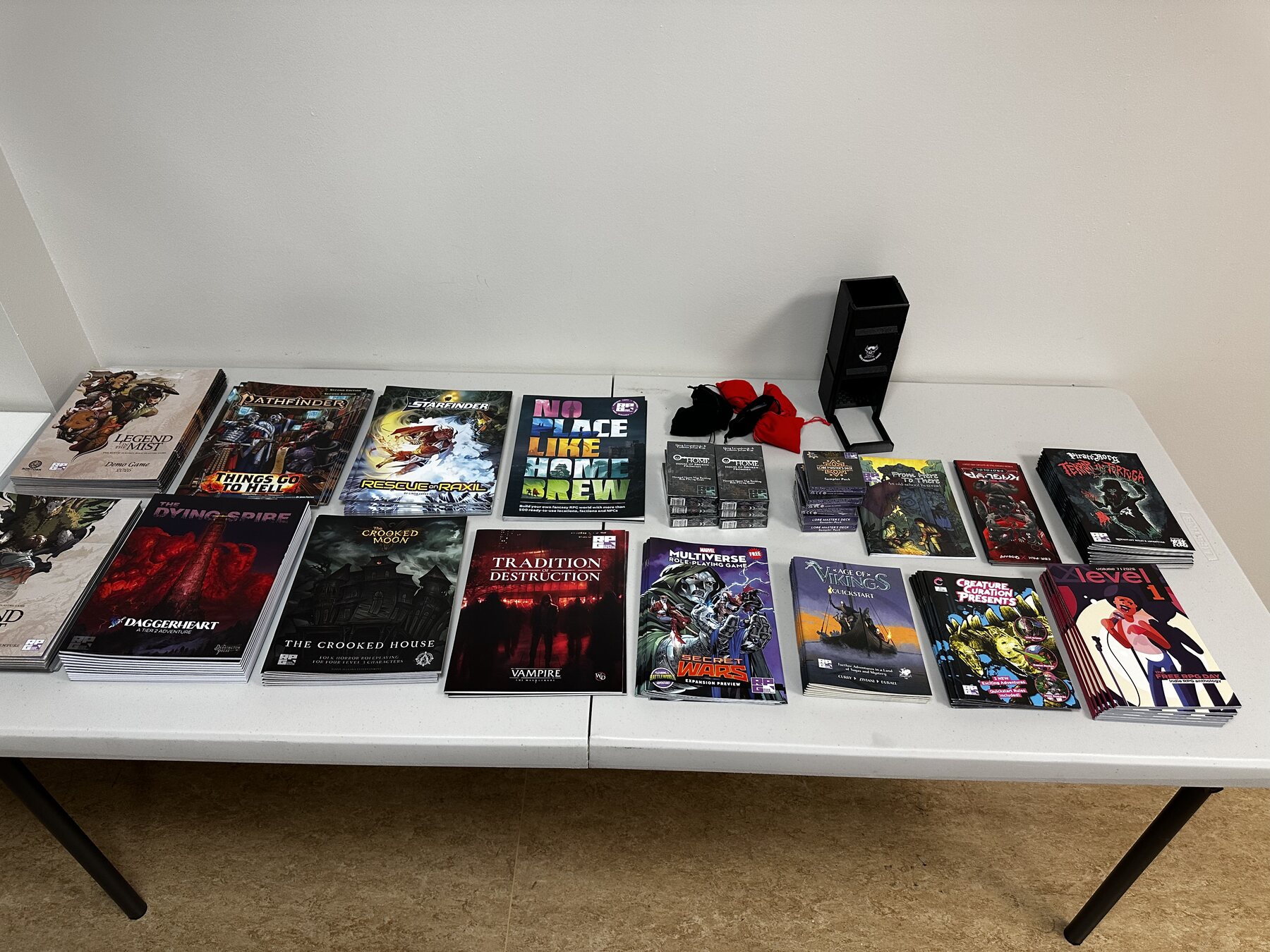 Auction books and prizes on display at Mighty Deeds Summer 2026